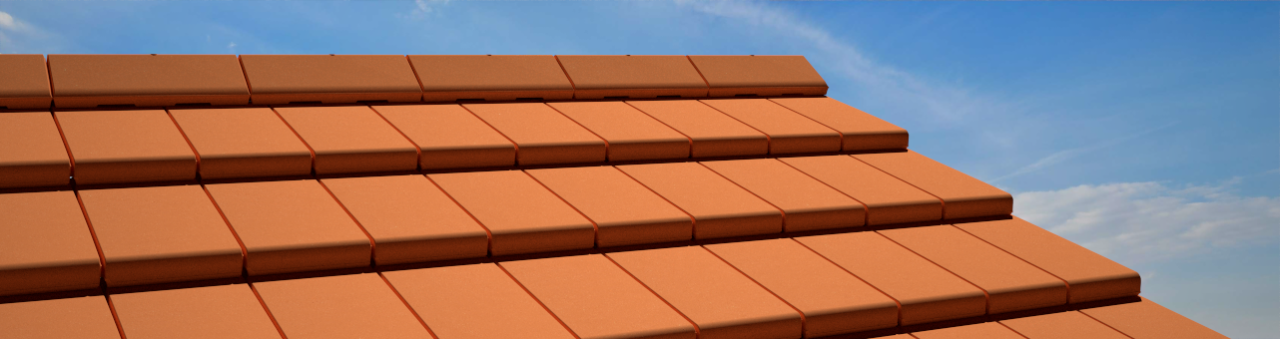 Rote Ziegeldachziegel unter blauem Himmel