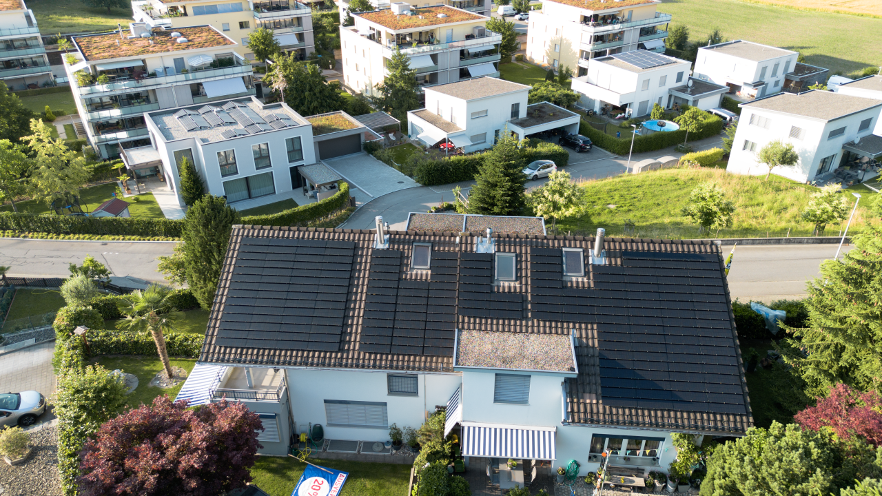 Luftaufnahme eines Wohngebiets mit modernen Einfamilienhaeusern und Gaerten